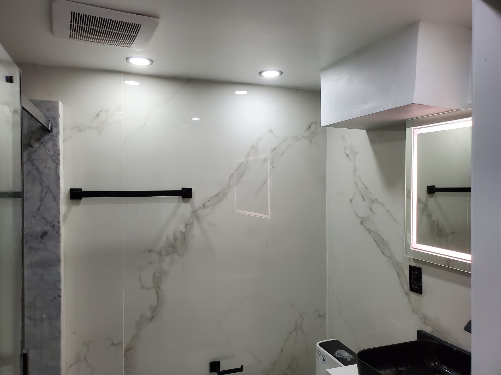 Marble-look bathroom walls with matte-black accessories