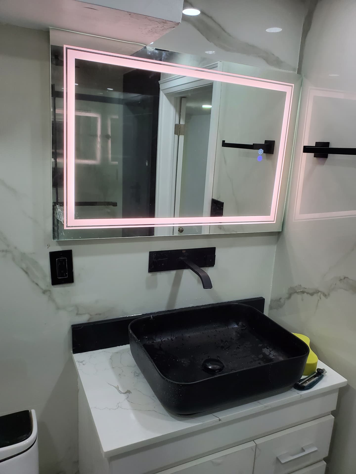 Black vessel sink with wall-mounted matte-black faucet