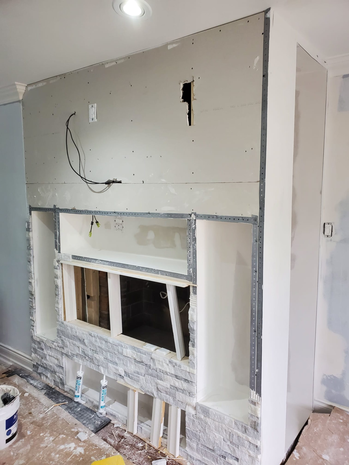 Feature wall under construction with steel-stud framing, drywall and rough electrical