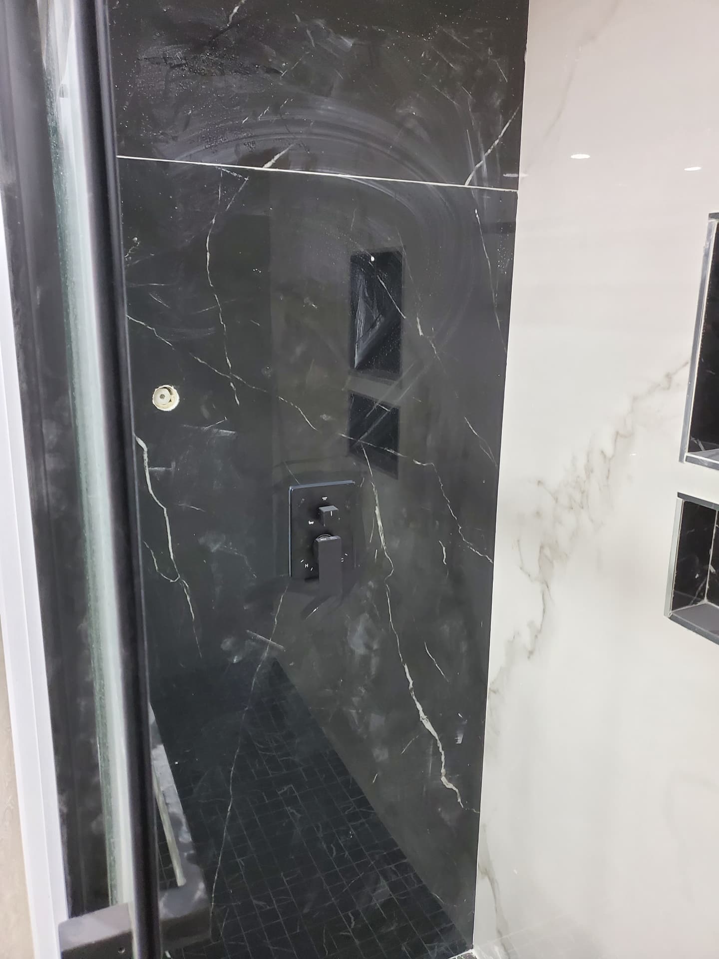 Black marble-look shower wall with matte-black controls