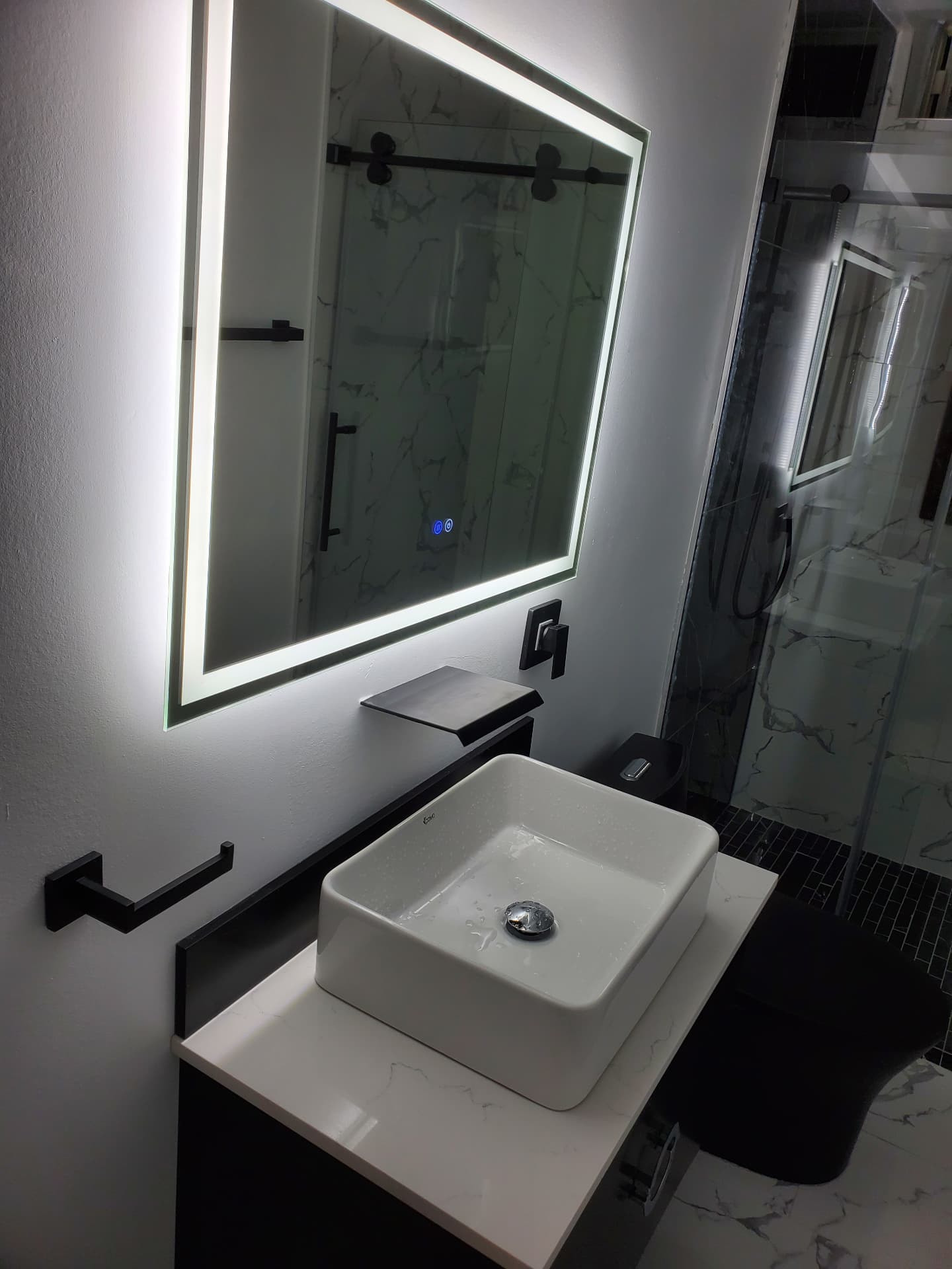 Finished vanity with LED backlit mirror, white vessel sink and matte black fixtures
