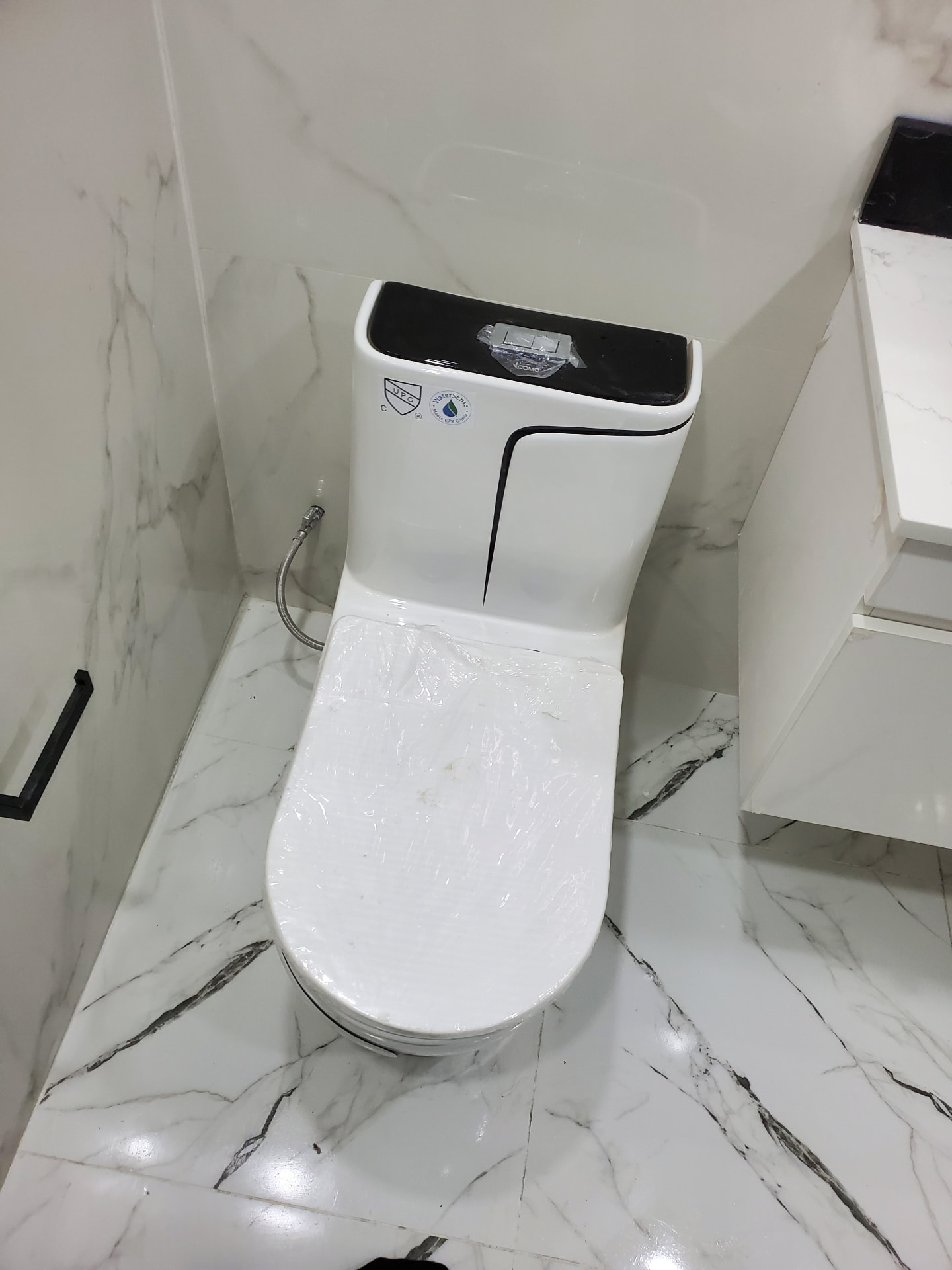Installed toilet on marble-look tile floor
