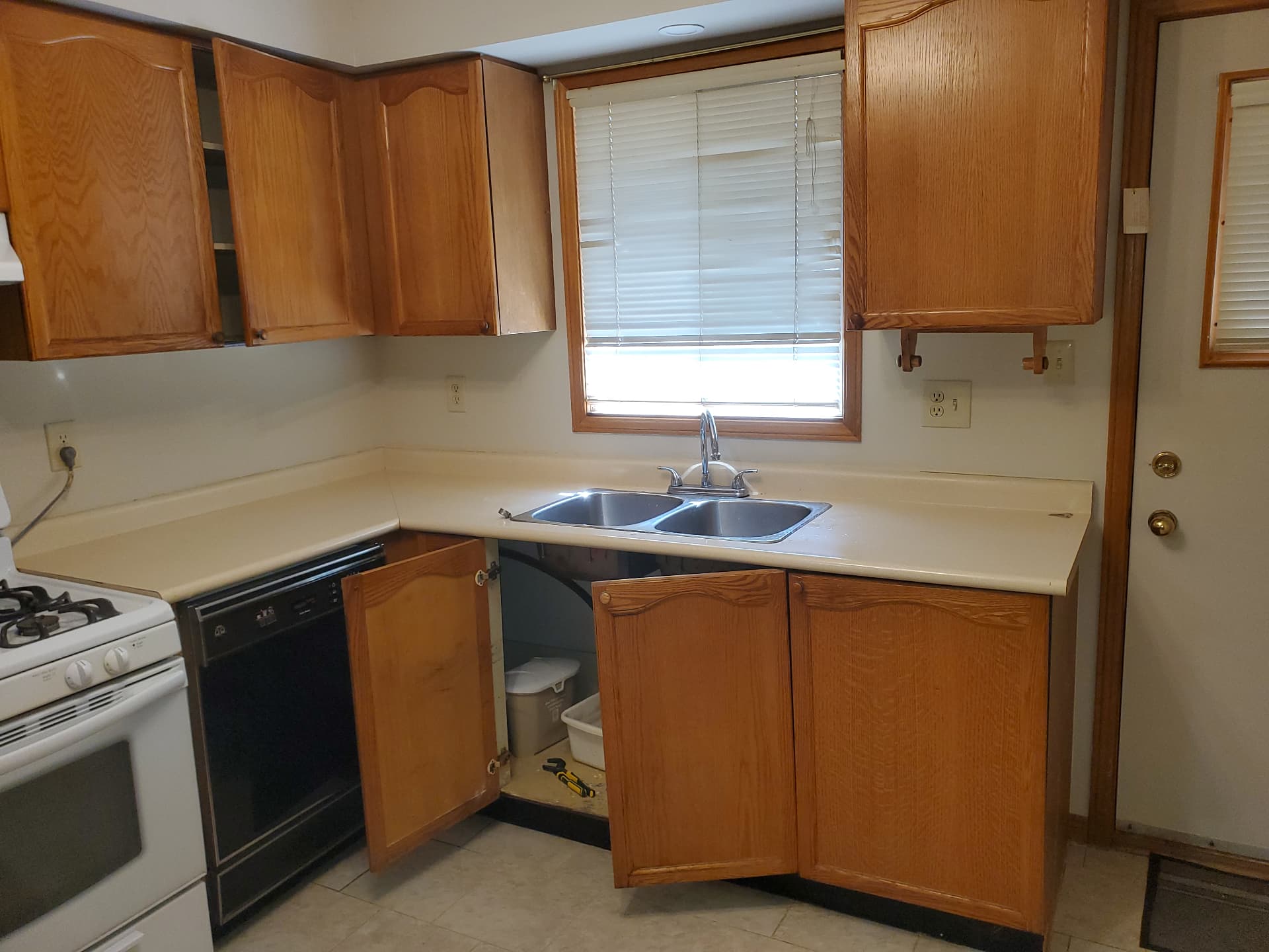 Original kitchen with dated wood cabinetry before renovation
