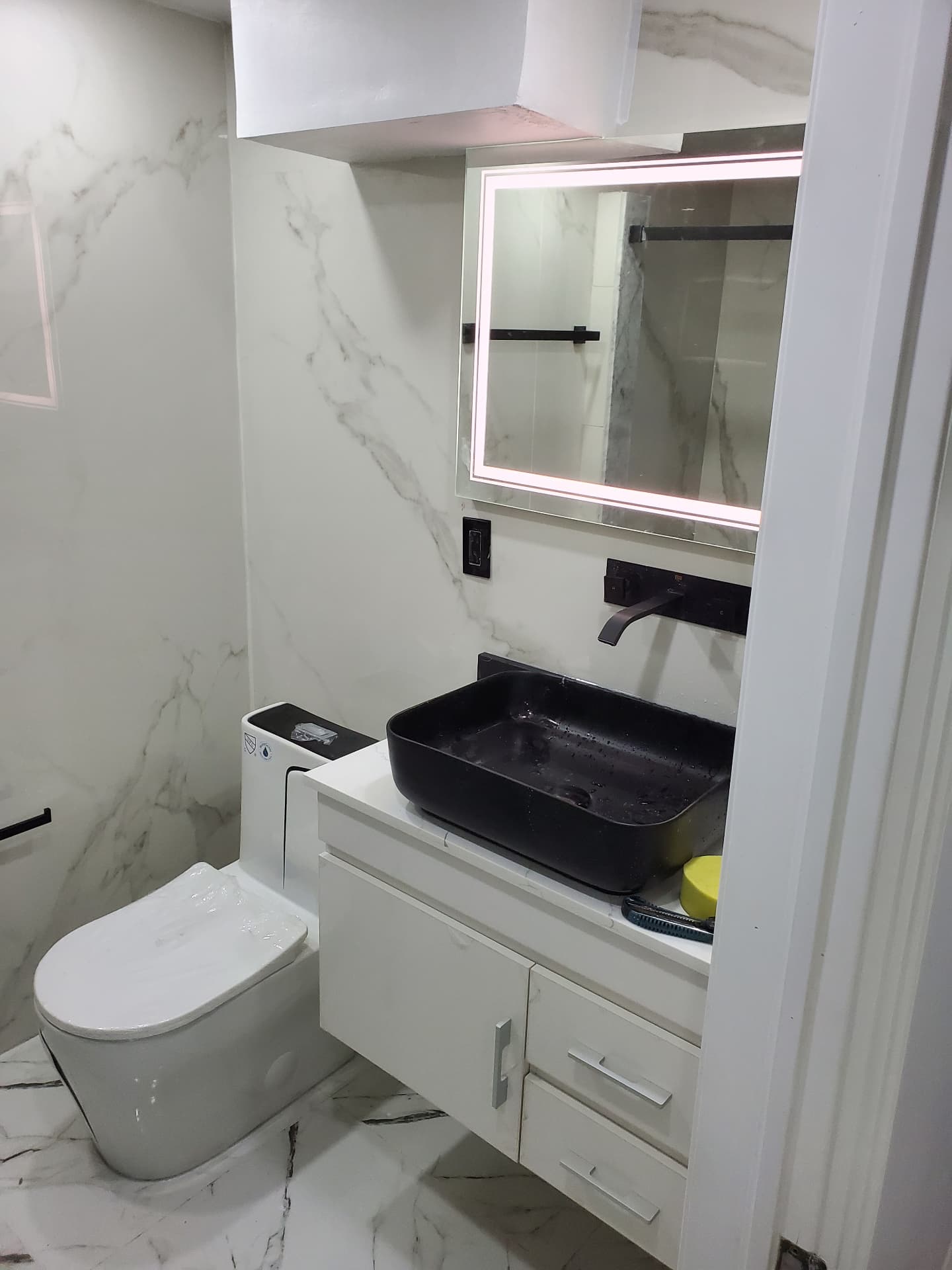 Completed bathroom with floating vanity and LED mirror