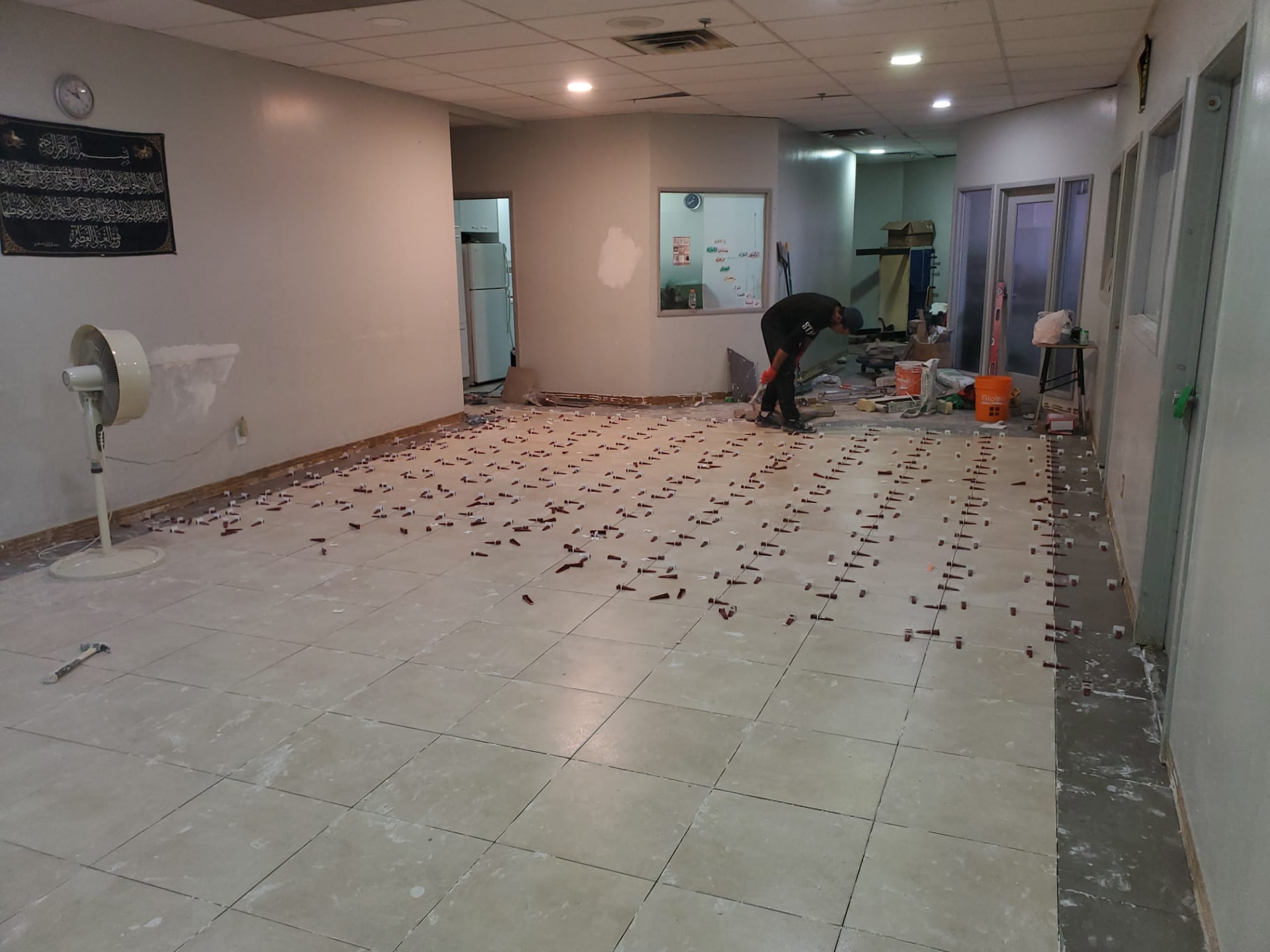 Wide view of tiled interior during construction with levelling clips still installed